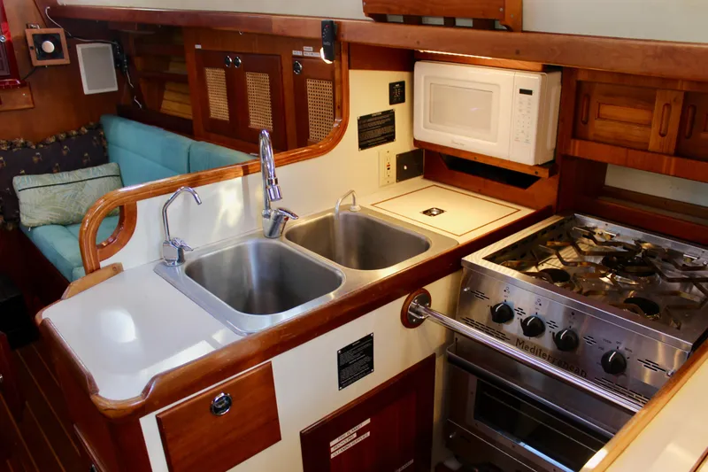Slide: The Image of 1997 Valiant 39 yacht kitchen with dual sinks, stove, and microwave. - 46
