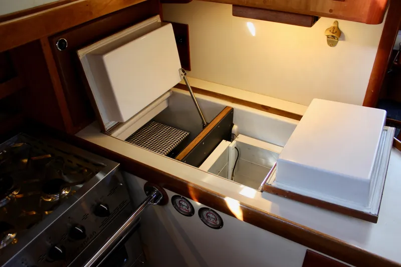 Slide: The Image of Interior of 1997 Valiant 39 yacht showing kitchen area with open storage compartments. - 50