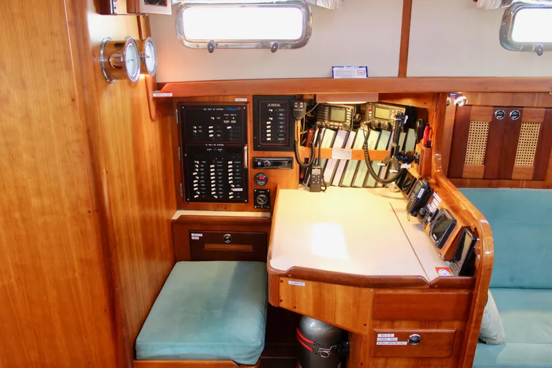 Slide: The Image of Navigation station inside 1997 Valiant 39 sailboat with control panels and communication equipment. - 52