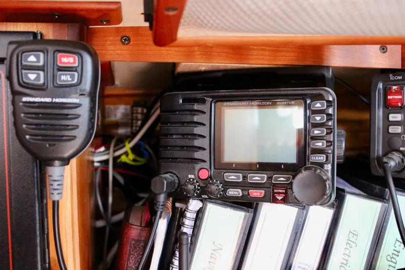 Slide: The Image of Radio equipment and manuals inside a 1997 Valiant 39 sailboat cabin. - 54