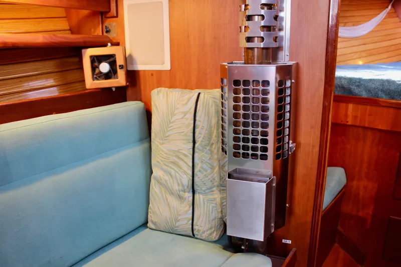 Slide: The Image of Cozy interior of a 1997 Valiant 39 sailboat with seating and a stainless steel heater. - 69