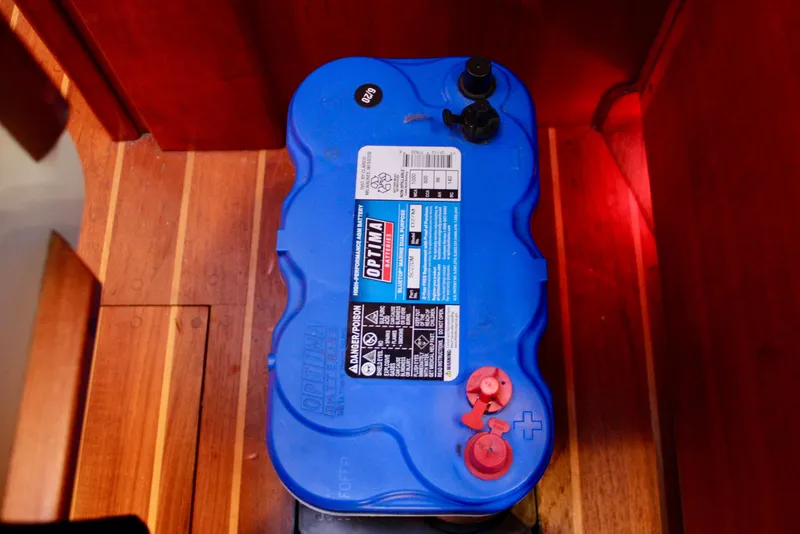Slide: The Image of Blue Optima battery inside a 1997 Valiant 39 boat, placed on wooden flooring. - 72