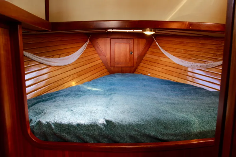 Slide: The Image of Cozy cabin interior of 1997 Valiant 39 sailboat with wooden paneling and blue bedding. - 73