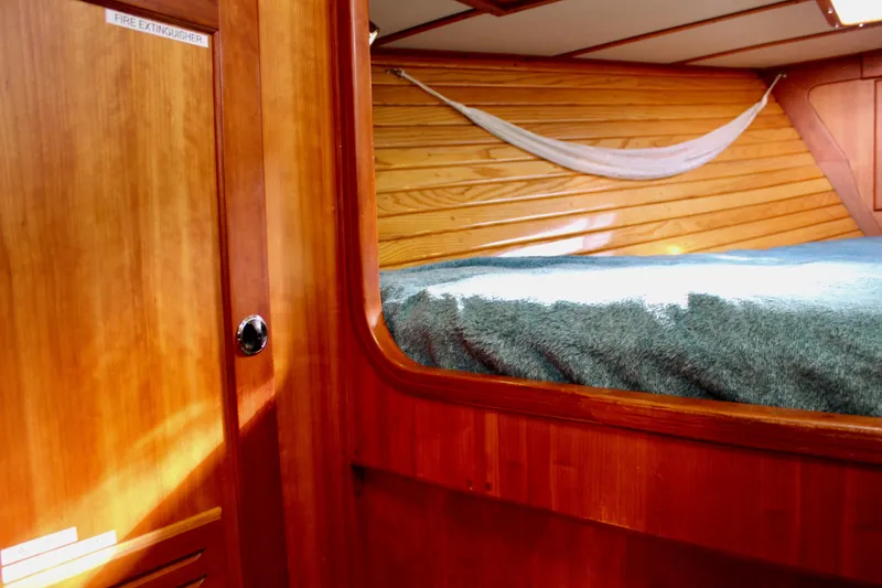 Slide: The Image of Interior of 1997 Valiant 39 sailboat with wooden paneling and cozy sleeping area. - 75