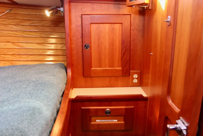Slide: The Image of Wooden interior of 1997 Valiant 39 sailboat with bed, cabinet, and electrical outlet. - 76