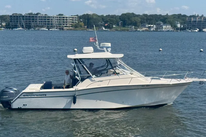 Slide: The Image of 2005 Grady-White Express 330 boat on calm water with scenic shoreline background. - 0