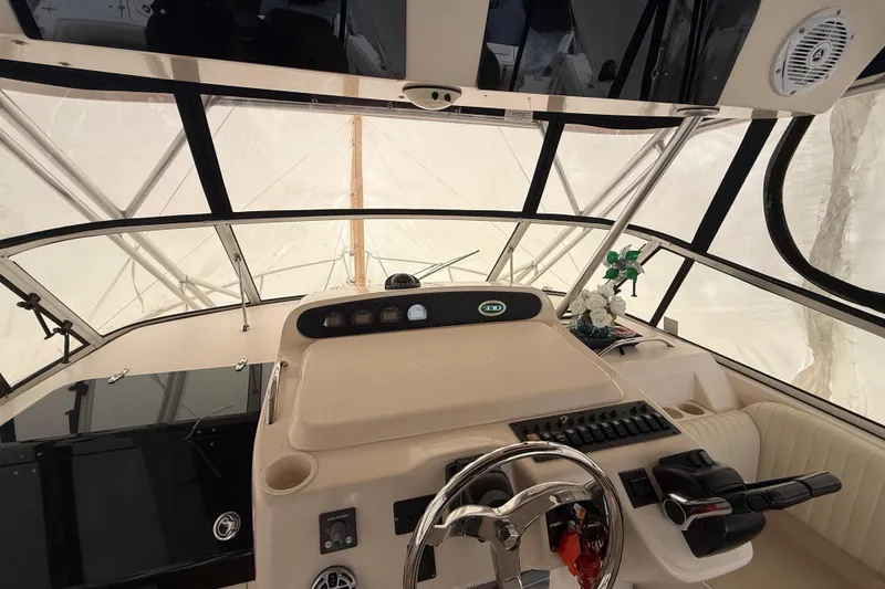 Slide: The Image of 2005 Grady-White Express 330 helm with steering wheel and control panel. - 23