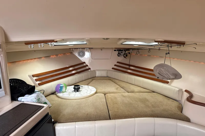 Slide: The Image of Interior cabin of 2005 Grady-White Express 330 boat, featuring cozy seating and fishing rods. - 26