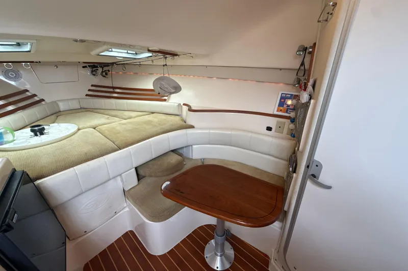 Slide: The Image of 2005 Grady-White Express 330 cabin interior with seating, table, and cozy sleeping area. - 30