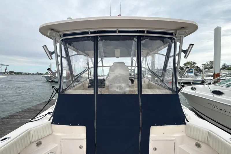 Slide: The Image of 2005 Grady-White Express 330 boat docked, featuring enclosed cockpit and marina background. - 32