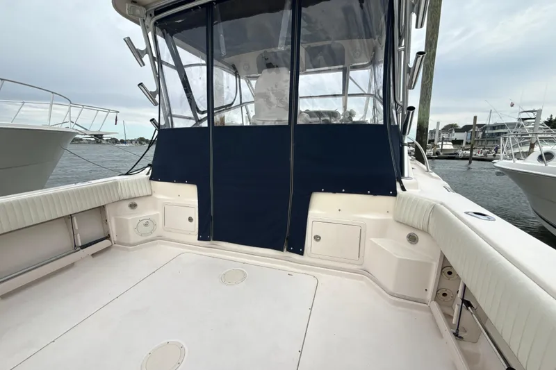 Slide: The Image of 2005 Grady-White Express 330 boat deck with seating and protective cover in marina. - 34