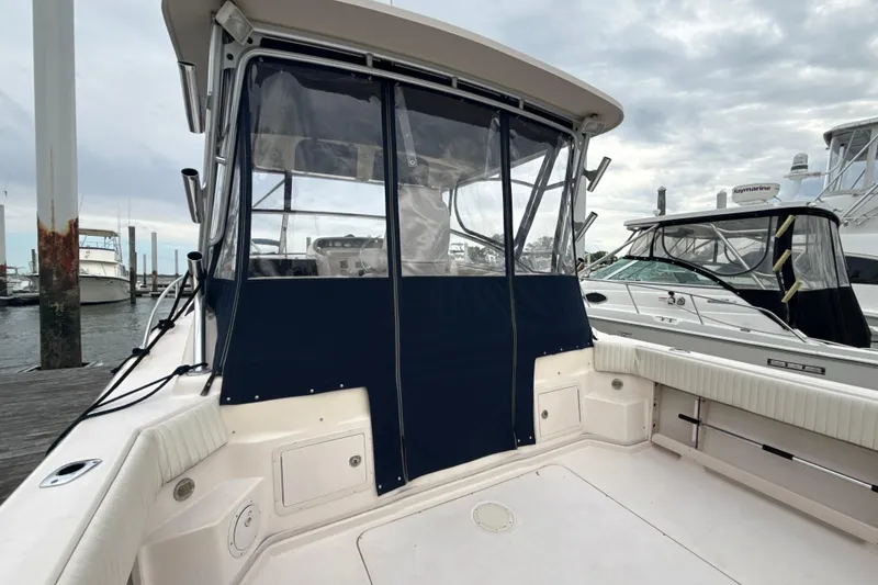 Slide: The Image of 2005 Grady-White Express 330 boat docked, featuring a covered cockpit area. - 36