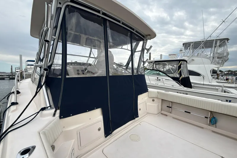 Slide: The Image of 2005 Grady-White Express 330 boat docked, featuring spacious deck and protective canopy. - 37