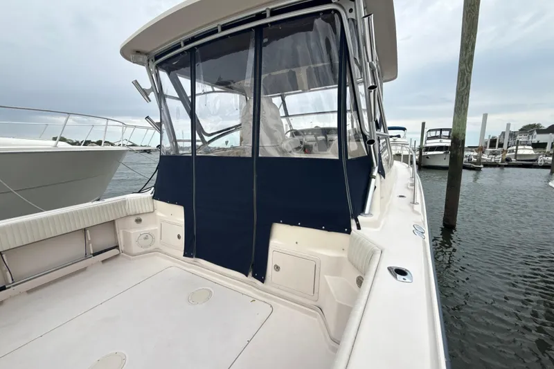 Slide: The Image of 2005 Grady-White Express 330 boat docked, featuring spacious deck and protective canopy. - 38
