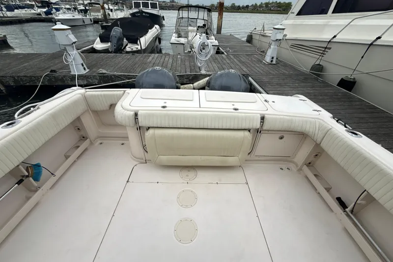 Slide: The Image of 2005 Grady-White Express 330 boat docked, showcasing spacious deck and seating area. - 41