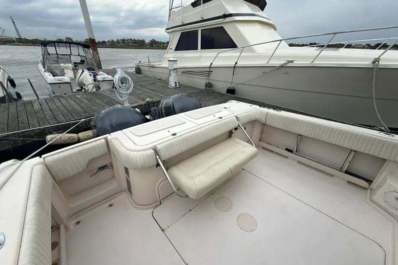 Slide: The Image of 2005 Grady-White Express 330 boat docked, featuring spacious seating and dual outboard motors. - 43