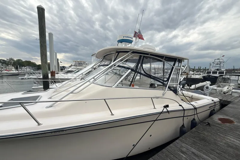 Slide: The Image of 2005 Grady-White Express 330 boat docked at marina under cloudy sky. - 48