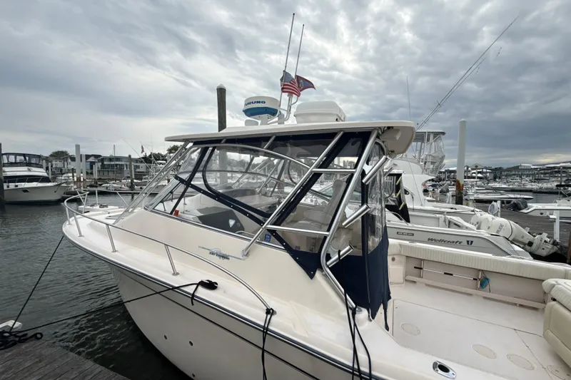 Slide: The Image of 2005 Grady-White Express 330 boat docked at a marina under cloudy skies. - 49