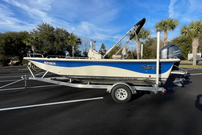 The Image of 2023 Carolina Skiff 21 LS boat on trailer, parked with palm trees in background. - 1
