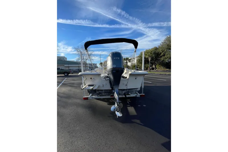 Slide: The Image of 2023 Carolina Skiff 21 LS boat with outboard motor in parking lot. - 2