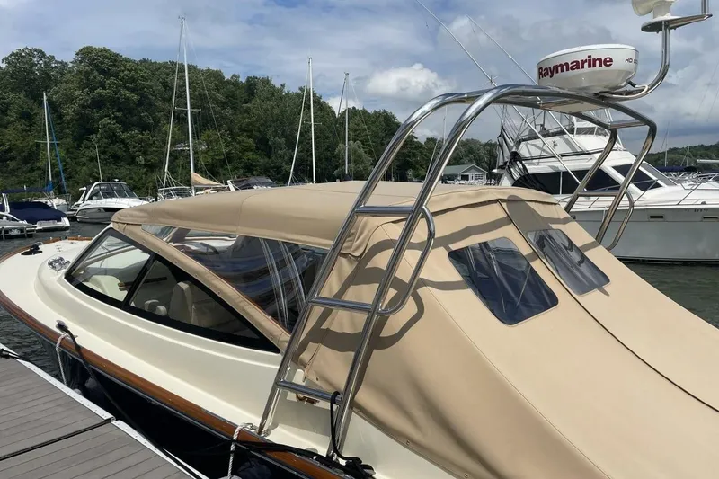Slide: The Image of 2012 Hinckley Runabout 38 docked, featuring beige canopy and Raymarine radar. - 2