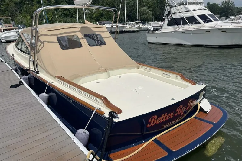 Slide: The Image of Hinckley Runabout 38, 2012 model, docked at a marina with a beige canopy. - 3