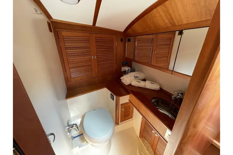 Slide: The Image of Luxurious 2012 Hinckley Runabout 38 bathroom with wooden cabinetry and modern fixtures. - 7