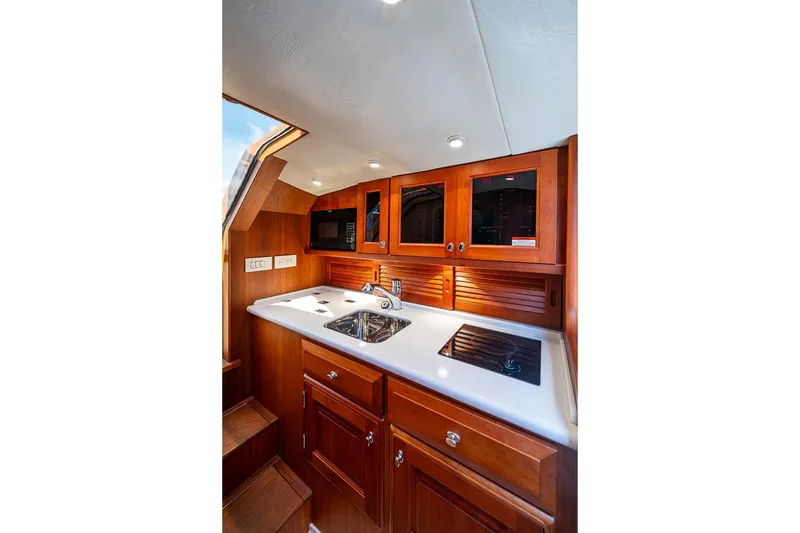 Slide: The Image of Luxurious 2012 Hinckley Runabout 38 yacht interior with elegant wooden cabinetry and modern amenities. - 10
