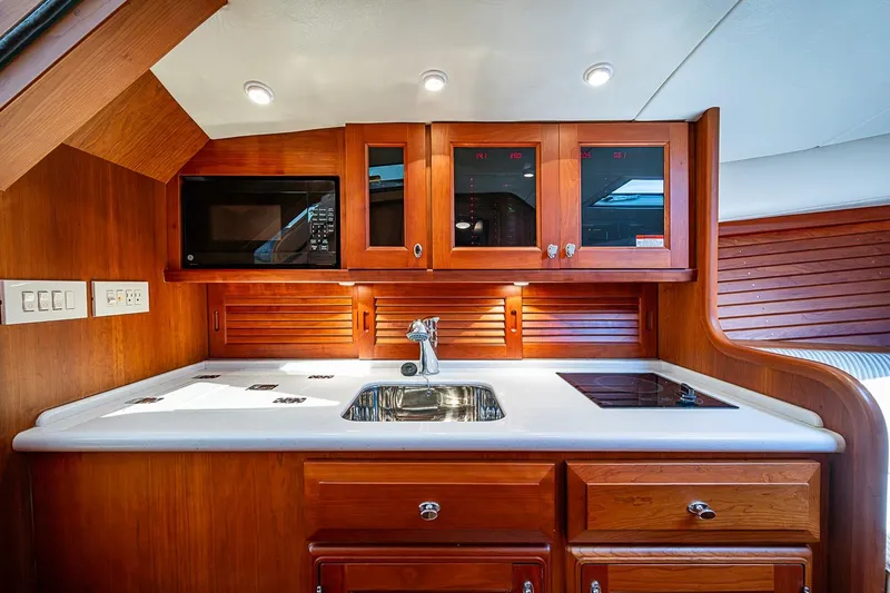Slide: The Image of Luxurious 2012 Hinckley Runabout 38 yacht kitchen with wood cabinetry and modern appliances. - 11