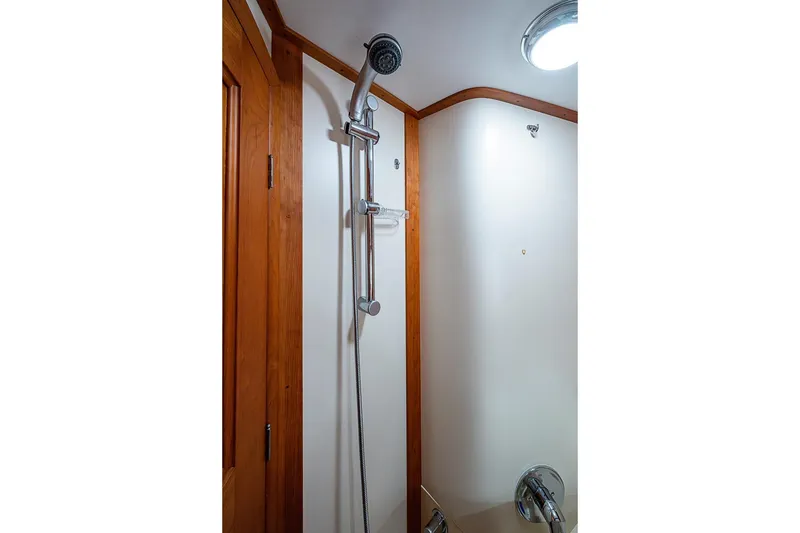 Slide: The Image of Shower area in 2012 Hinckley Runabout 38, featuring wooden trim and modern fixtures. - 14