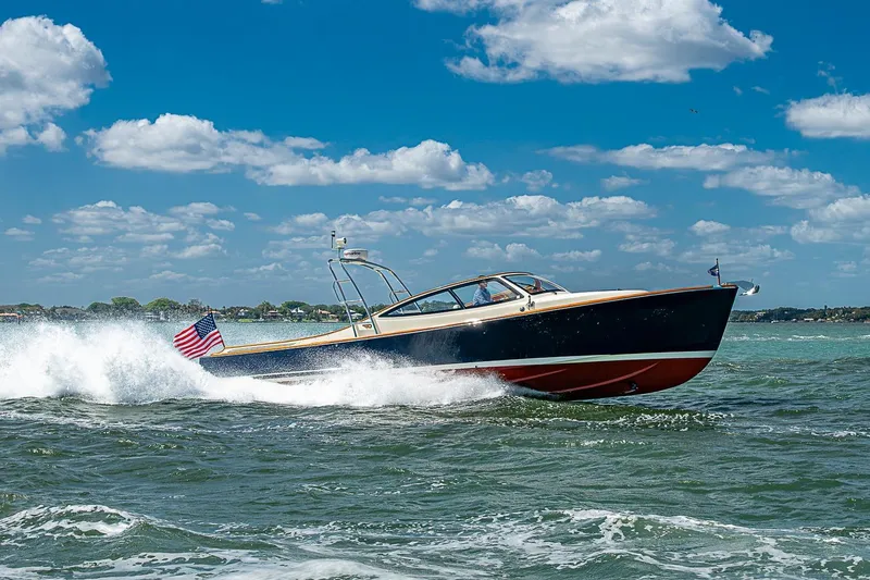 Slide: The Image of Hinckley Runabout 38 (2012) cruising on open water under a clear blue sky. - 18