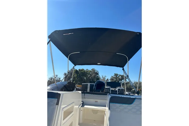Slide: The Image of 2022 Bayliner Element M17 boat with canopy under clear blue sky. - 12