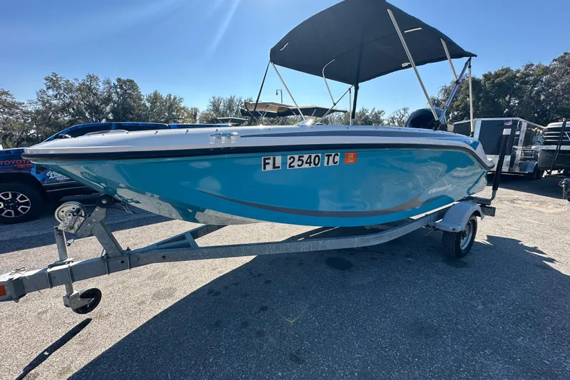 Slide: The Image of 2022 Bayliner Element M17 boat on trailer, blue hull, parked outdoors. - 20