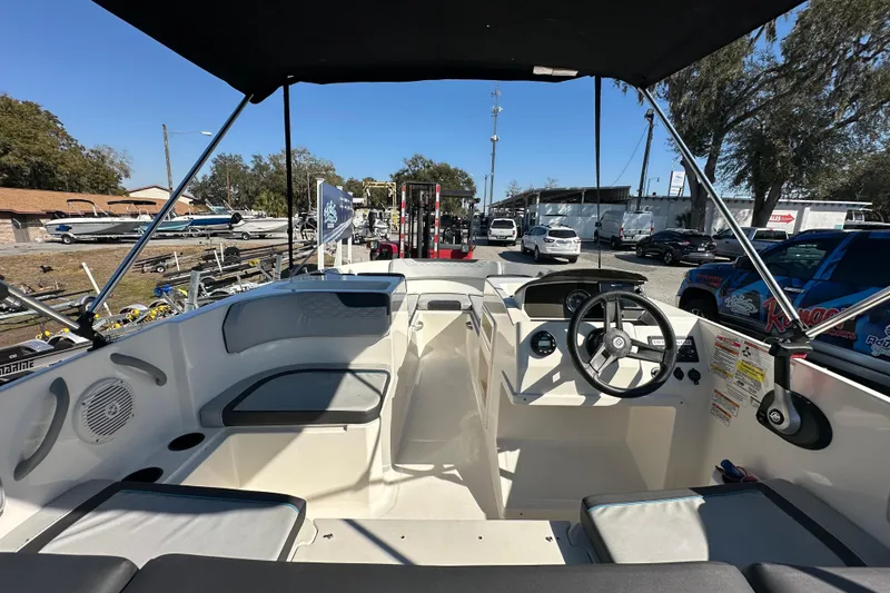 Slide: The Image of 2022 Bayliner Element M17 boat interior with steering wheel and seating, parked outdoors. - 6