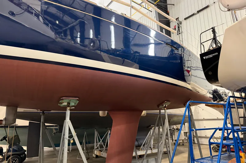 Slide: The Image of 2006 Beneteau First 36.7 sailboat in indoor storage, supported by stands. - 11