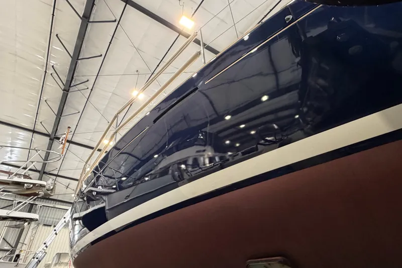Slide: The Image of 2006 Beneteau First 36.7 sailboat in indoor storage, showcasing sleek hull design. - 18