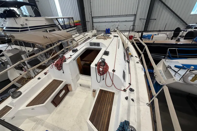 Slide: The Image of 2006 Beneteau First 36.7 sailboat in indoor storage, showcasing deck and cockpit area. - 23