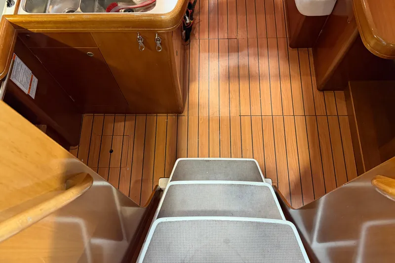 Slide: The Image of Interior of 2006 Beneteau First 36.7 yacht with wooden flooring and compact kitchen area. - 42