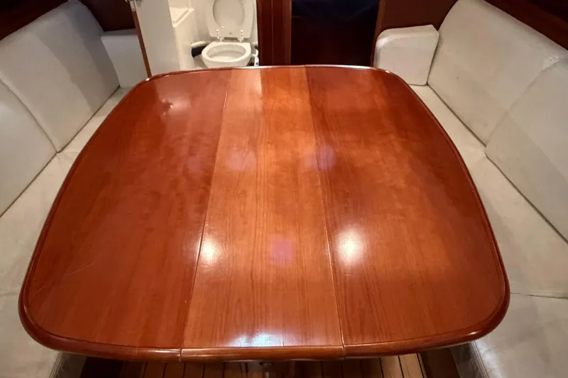 Slide: The Image of Interior of 2006 Beneteau First 36.7 yacht with wooden table and white seating. - 48