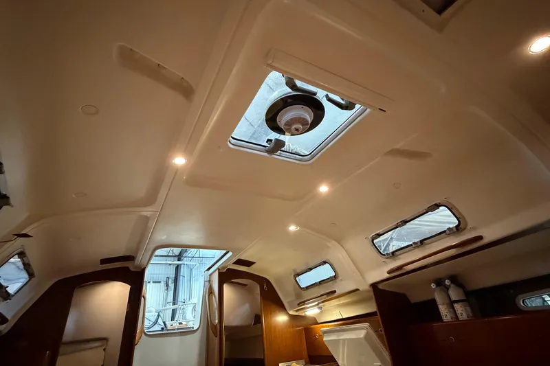 Slide: The Image of Interior view of 2006 Beneteau First 36.7 sailboat cabin with skylights and wooden accents. - 49