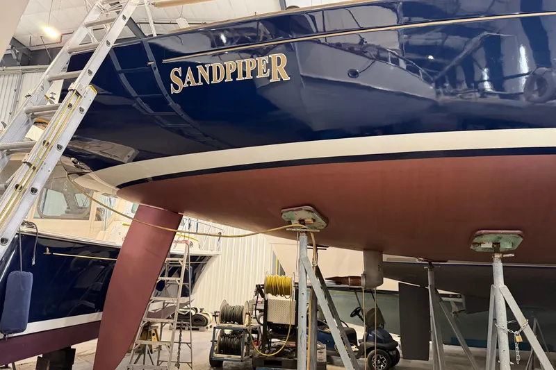 Slide: The Image of 2006 Beneteau First 36.7 sailboat "Sandpiper" in dry dock, blue hull, maintenance setting. - 5