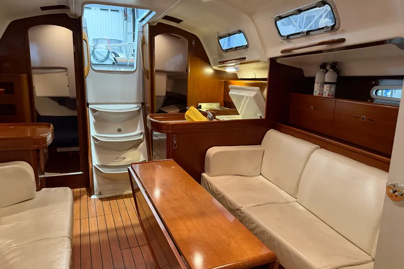 Slide: The Image of Interior of 2006 Beneteau First 36.7 sailboat with wood finish and cozy seating area. - 50