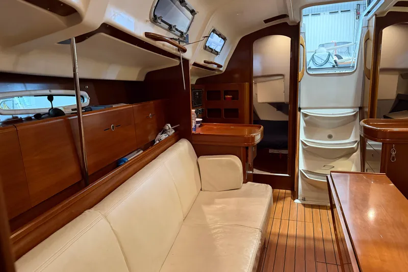 Slide: The Image of Interior of 2006 Beneteau First 36.7 sailboat with wooden furnishings and white seating. - 51
