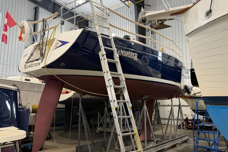 Slide: The Image of 2006 Beneteau First 36.7 sailboat in dry dock, with Canadian flag and ladder. - 8