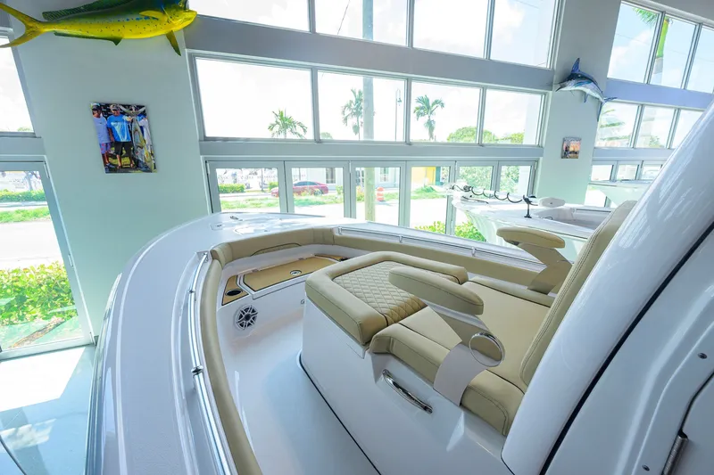 Slide: The Image of 2026 Sportsman Masters 247OE Bay Boat interior with luxurious seating in a sunlit showroom. - 9