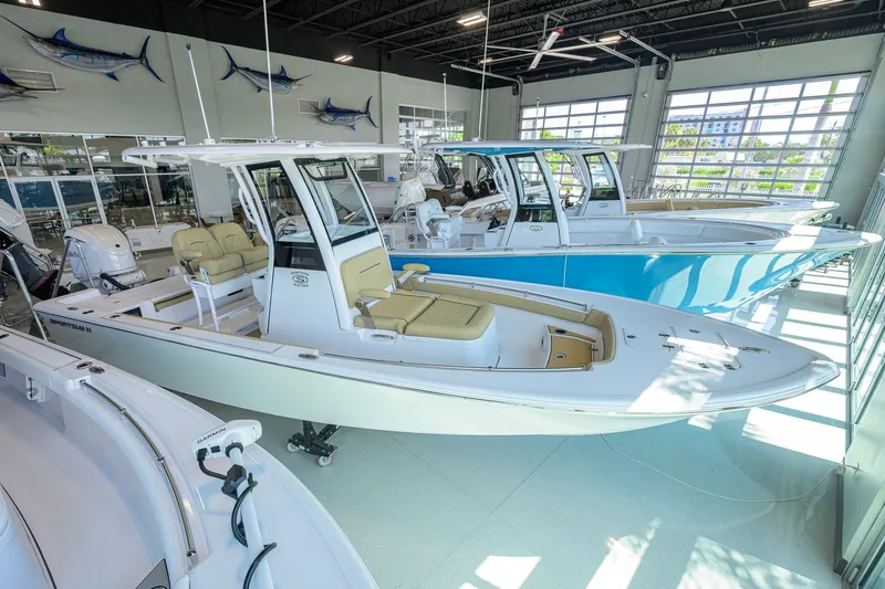 The Image of 2026 Sportsman Masters 247OE Bay Boat displayed in a showroom with other boats. - 0
