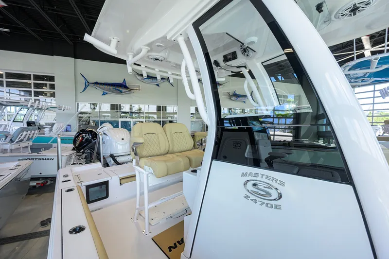 Slide: The Image of 2026 Sportsman Masters 247OE Bay Boat interior with seating and helm in showroom. - 20