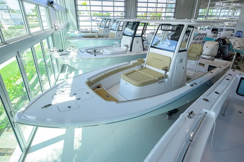 Slide: The Image of 2026 Sportsman Masters 247OE Bay Boat displayed in a showroom with large windows. - 1