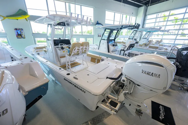 Slide: The Image of 2026 Sportsman Masters 247OE Bay Boat in showroom, featuring Yamaha engine. - 2