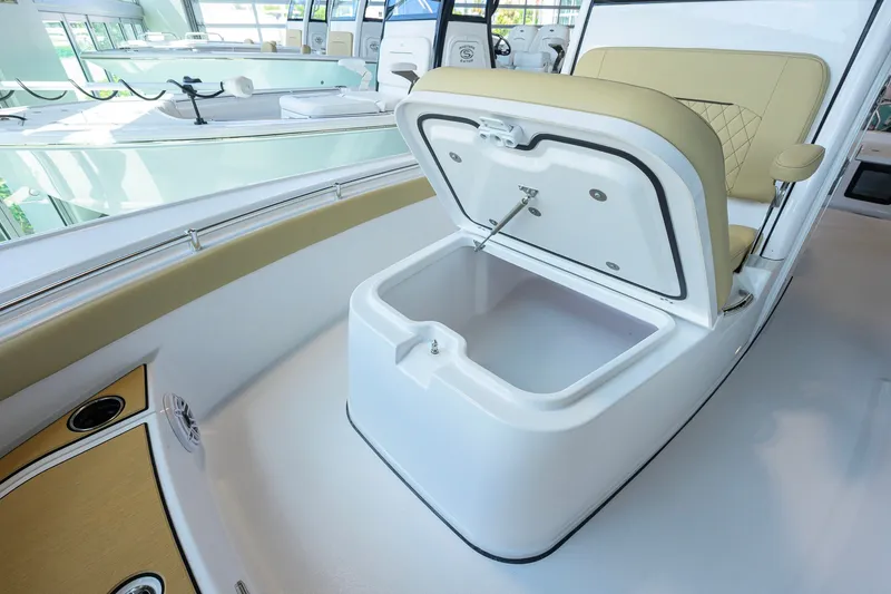 Slide: The Image of 2026 Sportsman Masters 247OE Bay Boat with open storage compartment and cushioned seating. - 17